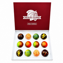 Load image into Gallery viewer, An open white box of 12 gourmet chocolate escapades from Chocolate Escapade, arranged in a 3x4 grid. The top lid is a deep burgundy red with a white logo.