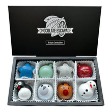 Load image into Gallery viewer, An open black gift box labeled 'CHOCOLATE ESCAPEAE' containing 8 decorated chocolates. Shaped like stars, a green ornament, a red ornament, a penguin, a bird, a reindeer figure, and a snowman, arranged in white paper cups.
