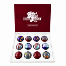 Load image into Gallery viewer, An open white gift box with a dark red lid printed with the brand name 'CHOCOLATE ESCAPEDE' and 'Artisan Confections'. Inside are 12 round gourmet chocolates with colorful marbled and glittery patterns in red, blue, purple, and gold.