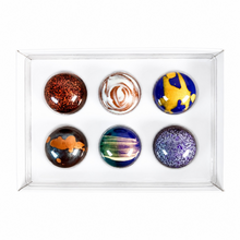 Load image into Gallery viewer, Six round chocolates in assorted colors and patterns, arranged in two rows inside a clear plastic tray on a white background.
